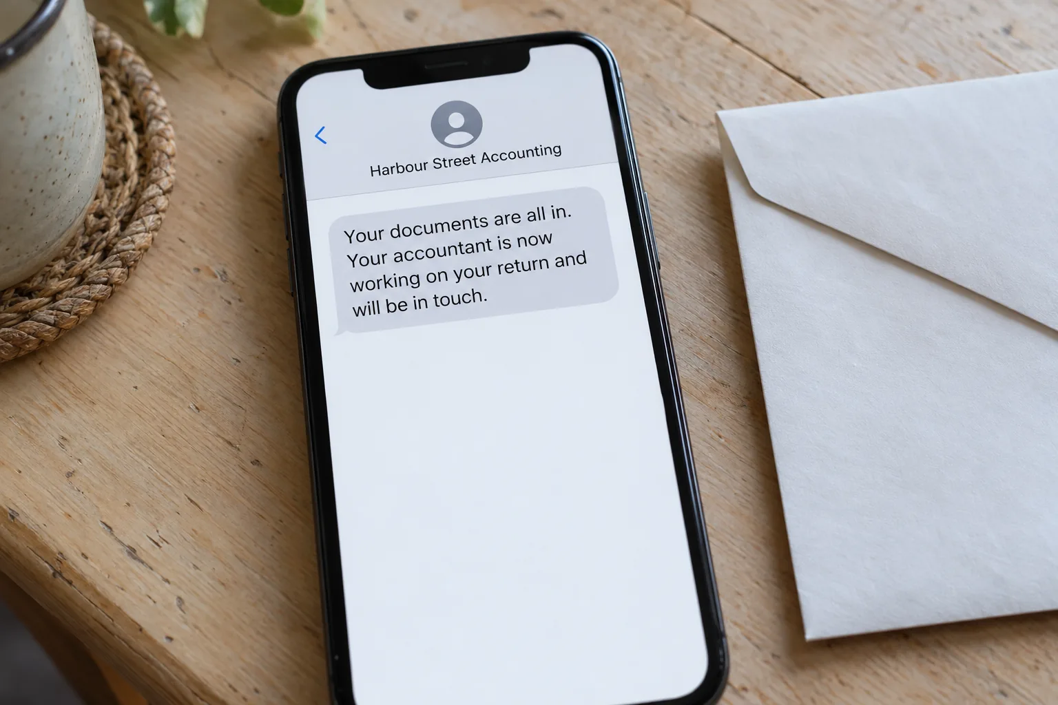 A phone showing a Harbour Street Accounting message that the client's documents are all in concept