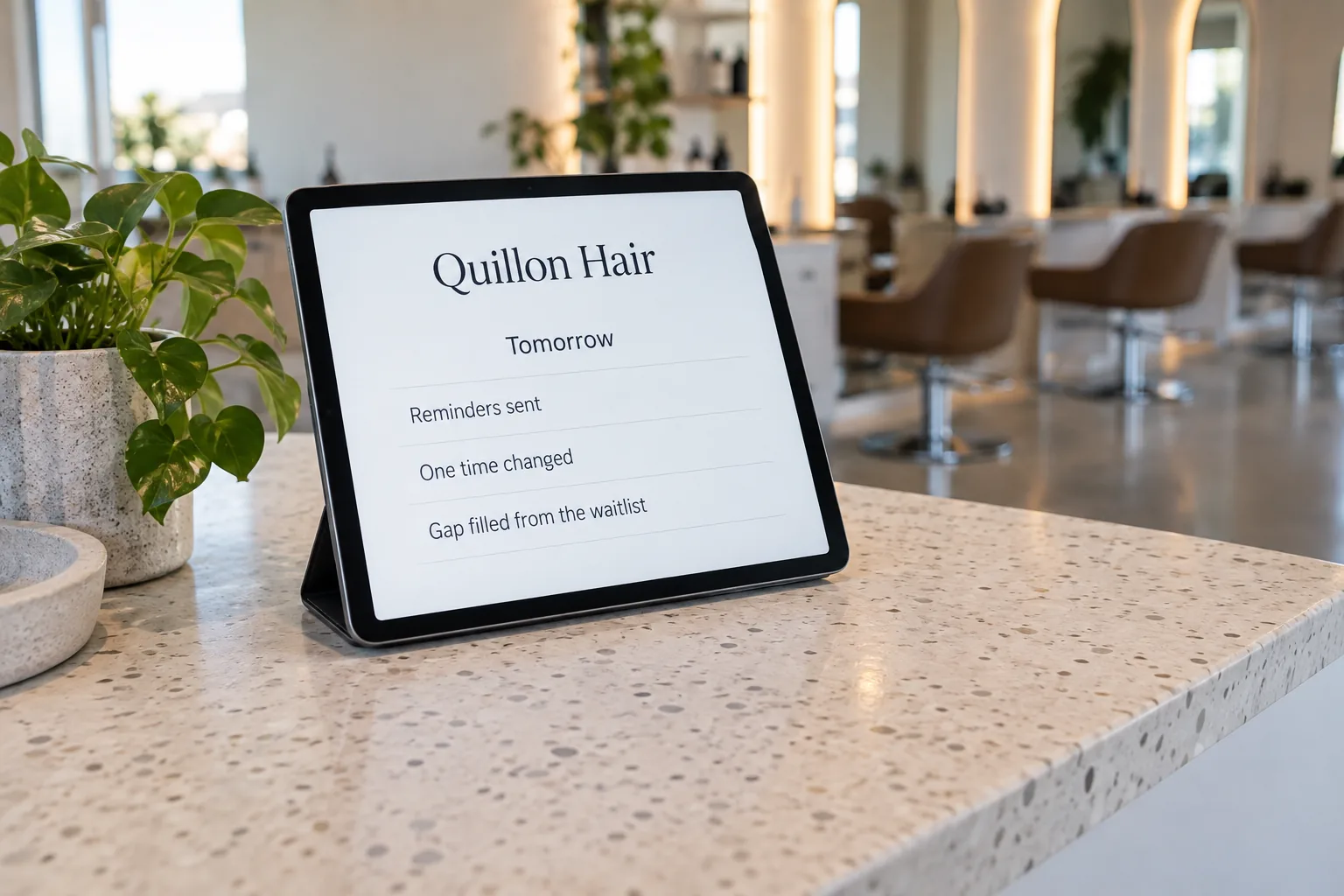 A tablet on a salon reception desk showing a Quillon Hair tomorrow schedule with a gap filled from the waitlist concept