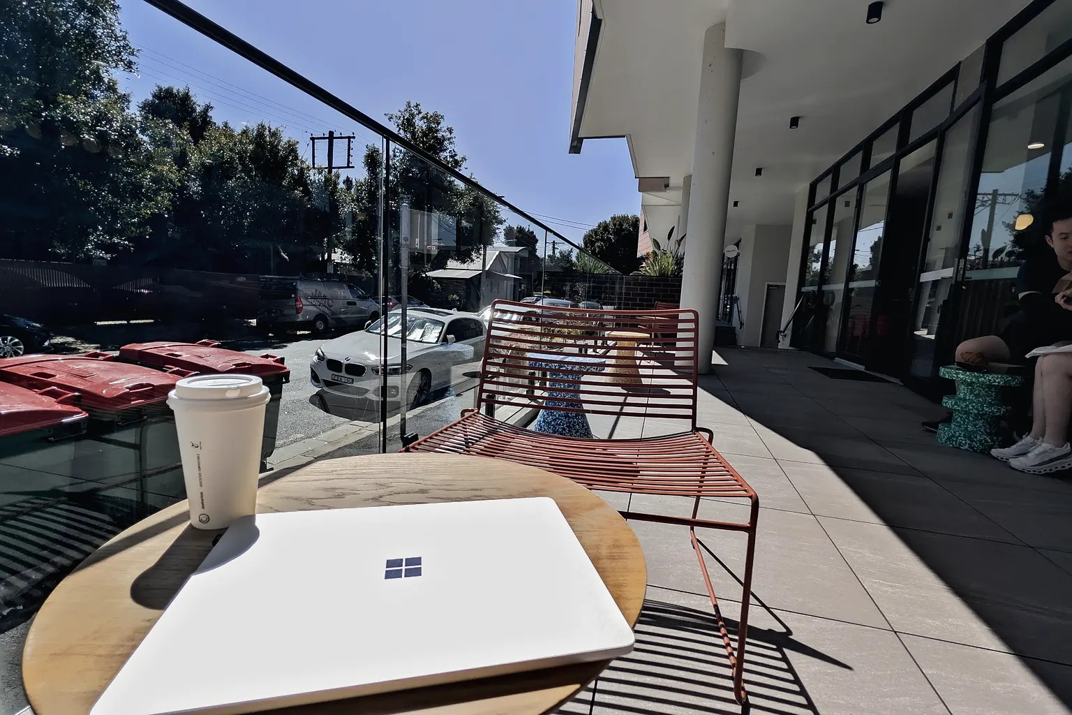 A laptop and a takeaway coffee on an outdoor table on Union Street, Wickham
