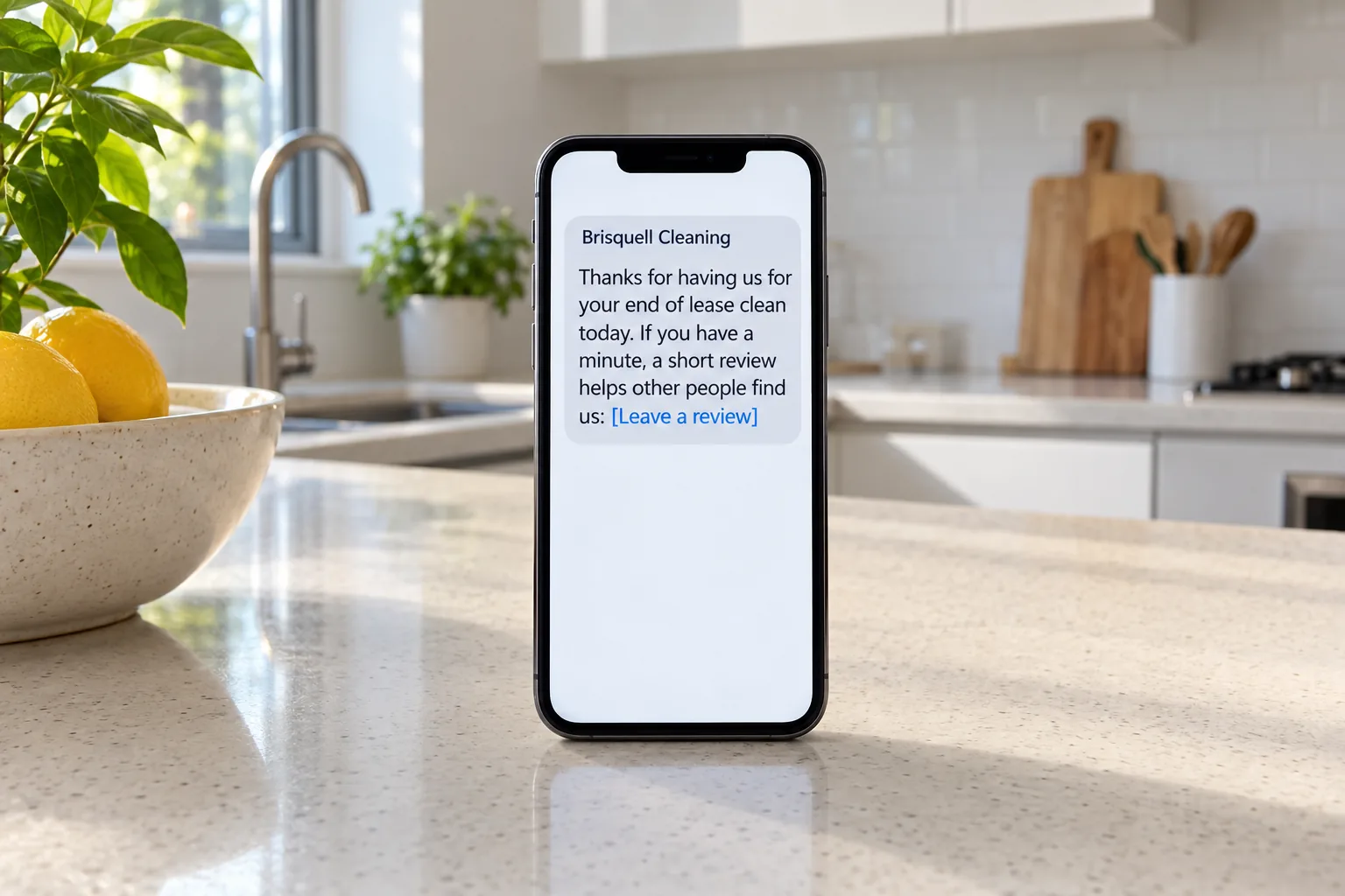 A phone on a kitchen bench showing a Brisquell Cleaning review request message concept