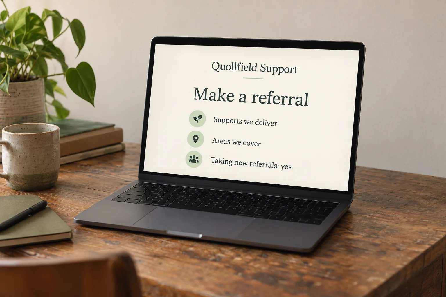 A laptop on an office desk showing a Quollfield Support make a referral page concept