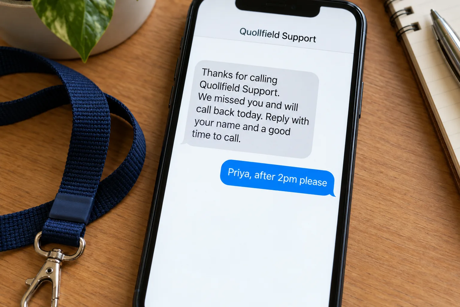 A phone on a desk showing a Quollfield Support missed-call text conversation concept