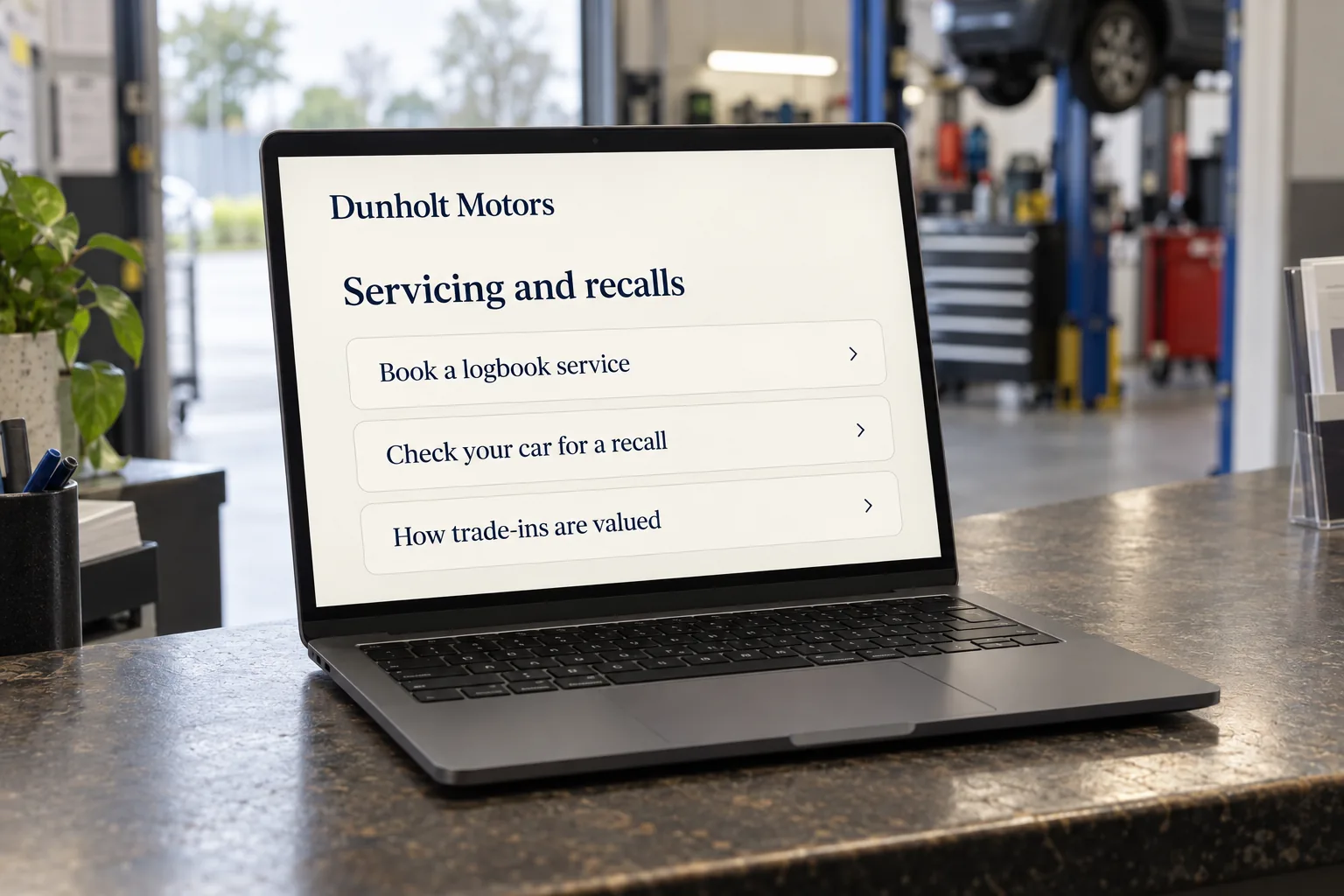 A laptop showing a Dunholt Motors servicing and recalls page concept