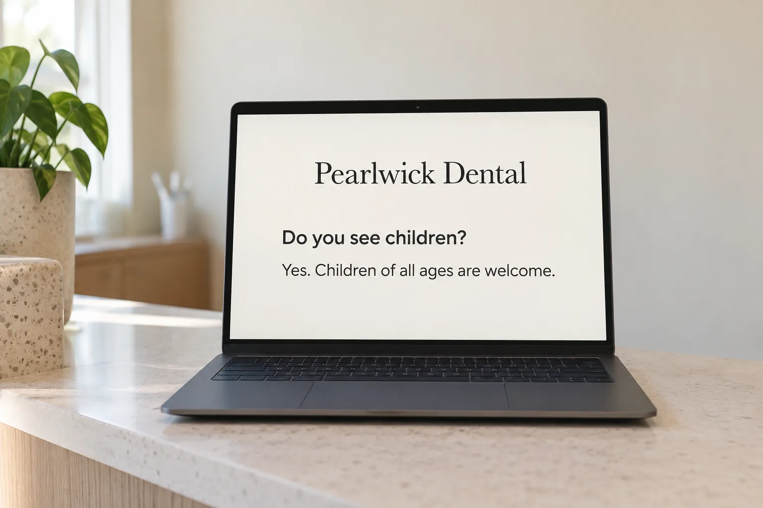 A laptop on a dental reception desk showing a Pearlwick Dental page answering a patient question concept