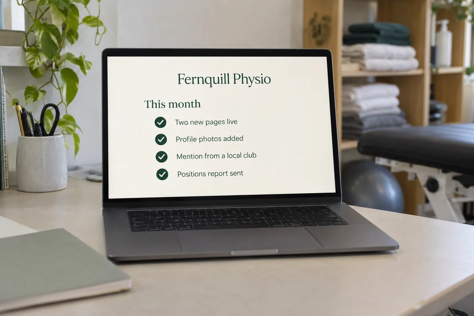 A laptop on a physio clinic desk showing a Fernquill Physio monthly SEO work list concept